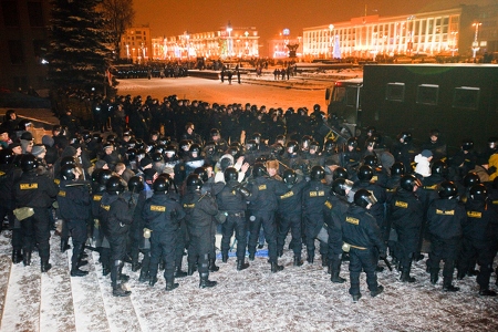 Poliser har bildat en korridor och misshandlar demonstranter innan de förs bort i polisens bilar. Hundratals personer, däribland ett antal presidentkandidater, greps på kvällen den 19 december 2010 vid demonstrationen mot presidentvalet tidigare på dagen. 