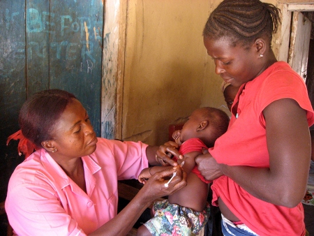 En hälsovårdsarbetare i en by i norra Sierra Leone ger en vaccination i februari 2009. Då hade hon inte fått lön av regeringen på fyra år. 