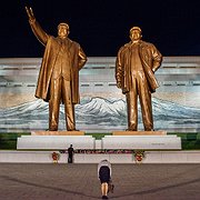 En kvinna bugar inför statyer på Kim Il-sung och sonen Kim Jong-il.