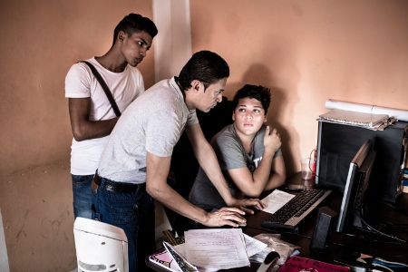 Brian Lobo och Ermen Castro arbetar med att skicka ut kuvert som innehåller hiv-information och kondomer. Iván Banegas hjälper killarna med de sista detaljerna.