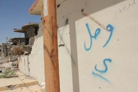 Enligt den kurdiska säkerhetstjänsten, Asayish, märktes hus som tillhörde yazidier och shiamuslimer i Sinjar City ut av IS. På bilden har den arabiska bokstaven "y" sprayats på väggen till ett sprängt hus för att markera att det ägdes av yazidier. 