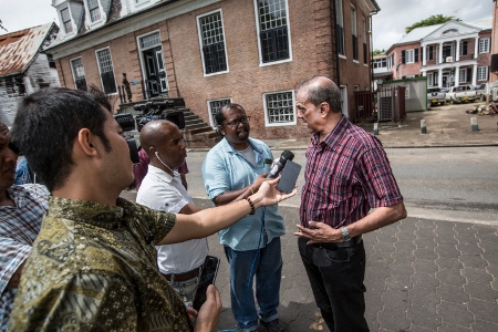Sunil Oemrawsingh, vars farbror var ett av mordoffren, blir intervjuad av journalister utanför Högsta domstolen i Paramaribo.