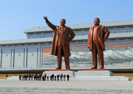 Nordkoreaner bugar framför statyer av Kim Il-sung och Kim Jong-il vid Mansudae-monumentet. 