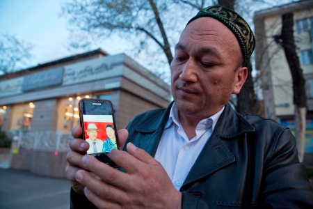 Omir Bekali, nu åter hemma i Kazakstan, visar ett foto på sina föräldrar som han tror är fängslade i Xinjiang.