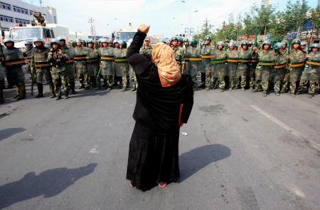 En ensam kvinna skriker i protest mot kinesisk polis den 7 juli 2009. Då skakades Xinjiangs huvudstad Ürümqi av sammandrabbningar mellan kineser och uigurer.