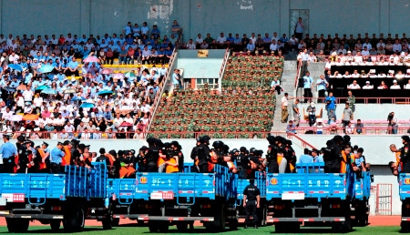 Xi Jinpings kampanj ”Slå hårt” inleddes våren 2014. Här hålls en offentlig massrättegång i Yili i Xinjiang den 27 maj 2014. Minst tre dödsdomar avkunnades när 55 personer dömdes för bland annat ”terrorism”.