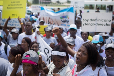  Hundratals statslösa personer protesterar utanför Konstitutionsdomstolen i Dominikanska republikens huvudstad Santo Domingo den 23 september 2016. Domstolen hade i sitt utslag 168-13 från år 2013 beslutat att tiotusentals personer med rötter i Haiti retroaktivt skulle berövas sina rättigheter. 