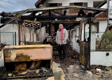Milan Jovanović framför sitt nedbrända hus i Belgradförorten Vrčin. Han och hans fru undkom oskadda genom att hoppa ut från baksidan. Mordbrännarna sköt också skott mot framsidan av huset.