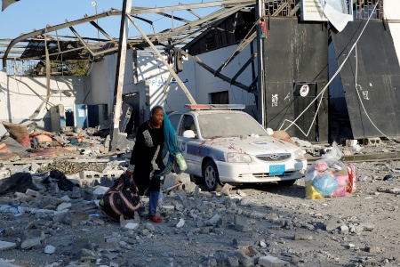 En kvinna samlar ihop sina ägodelar i förvaret Tajoura utanför Libyens huvudstad Tripoli efter flyganfallet natten till 3 juli. 