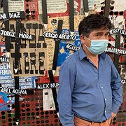 Anselmo Acuña, står framför ett provisoriskt monument över de som har dött under protesterna i Chile. Han står bredvid ett kors med sin sons namn. 