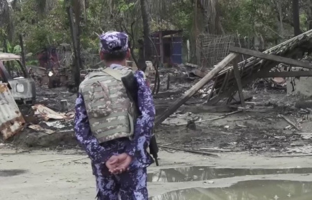 Omkring 700 000 rohingyer fördrevs från Rakhine hösten 2017. Här inspekterar en medlem i Myanmars gränspolis nedbränt hus.